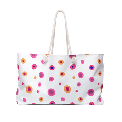 Travel Bag Yellow and Pink Circles features a vibrant design with pink and orange circles, a white pom, and durable rope handles, ideal for cheerful, stylish getaways.