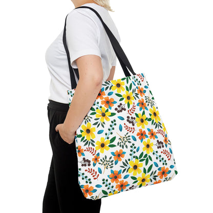 Sunny Meadow Mix Tote Bag with vibrant yellow and orange florals, green leaves, and small berries, carried over the shoulder, showcasing its spacious, stylish design, perfect for summer adventures and joyful outings.