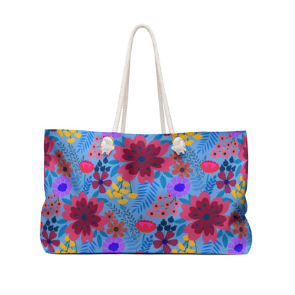 Weekender Bag with vibrant floral design, large rectangular shape, thick white rope handles, and a light blue background, perfect for stylish travel.