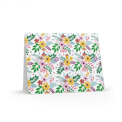 Floral Greeting Cards — Pack of 8/16/24 feature a vibrant, hand-drawn botanical pattern with wildflowers and leaves. The cards stand open, showcasing their elegant matte finish and matching white envelopes.