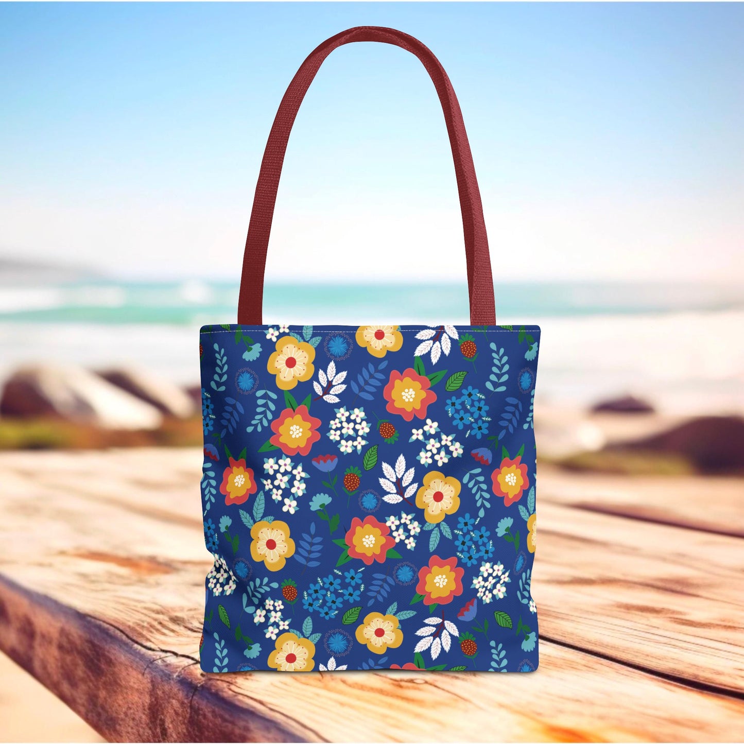 Floral Tote Bag with navy-blue body, bright stylized flowers, and maroon handles, perfect for summer outings. Durable and cheerful, it enhances joyful, stylish living from FireBrook Essentials.