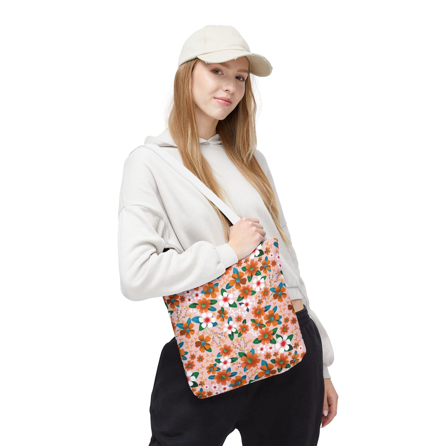 Young woman with a Floral Tote Bag featuring orange and white blossoms on peachy-pink, exemplifying FireBrook Essentials' stylish, joyful designs. Ideal for summer outings, with durable polyester and reinforced handles.