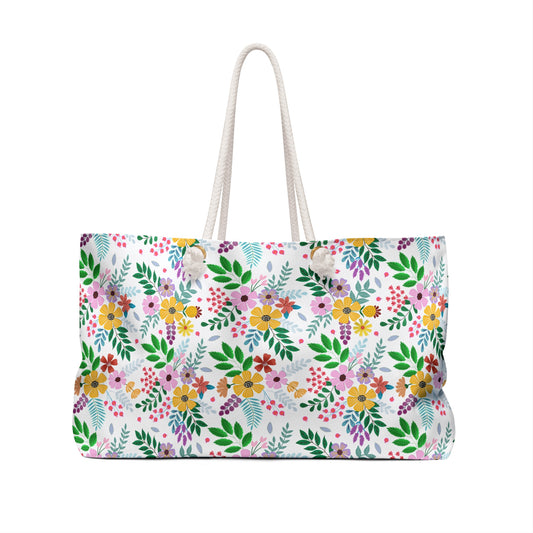 Weekender Bag with vibrant floral pattern and sturdy white rope handles, embodying FireBrook Designs' joyful style. Perfect for travel, featuring a spacious interior and luxurious cream lining.