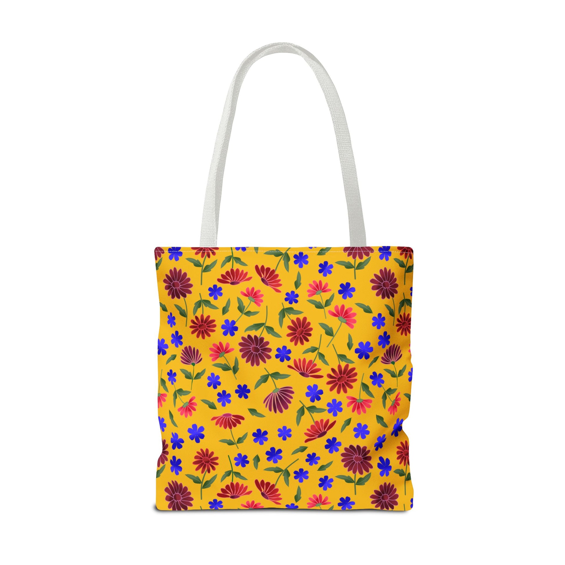 Golden Wildflower Tote Bag with bright yellow background, featuring red-pink daisies, cobalt-blue flowers, and green leaves. White straps complement its cheerful design, embodying FireBrook Essentials' joyful and stylish ethos.