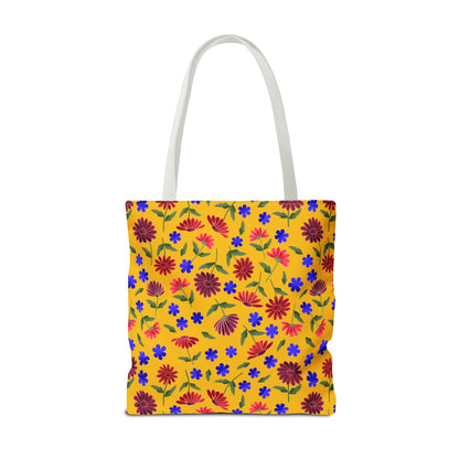 Golden Wildflower Tote Bag with bright yellow background, featuring red-pink daisies, cobalt-blue flowers, and green leaves. White straps complement its cheerful design, embodying FireBrook Essentials' joyful and stylish ethos.