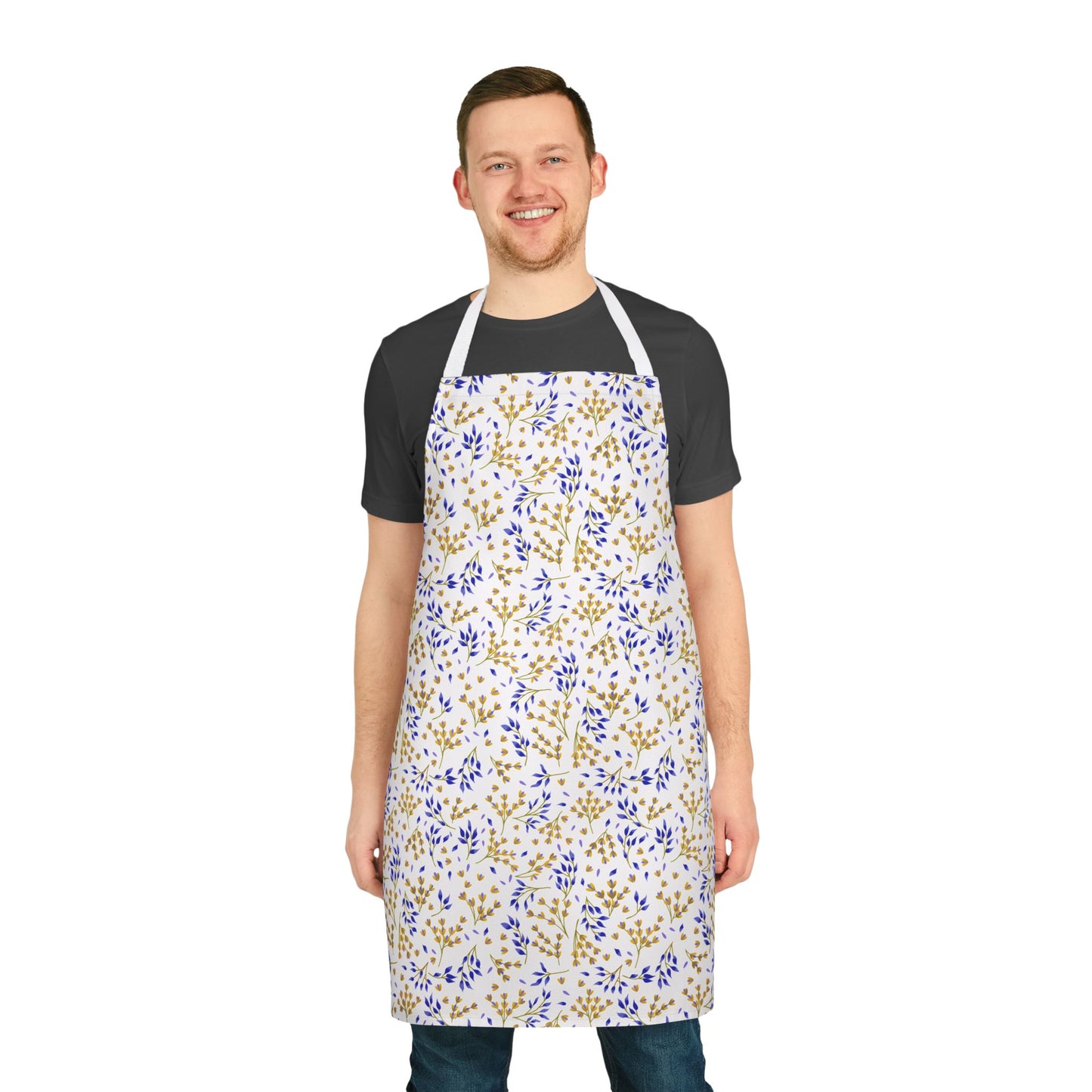 Smiling young man wearing FireBrook Designs' Floral Apron, showcasing delicate gold and blue botanical patterns on a white polyester canvas, ideal for stylish, comfortable cooking or crafting.