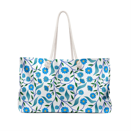 Weekender Bag with rope handles, featuring a floral pattern of blue flowers and green leaves on white, offers a stylish and spacious option for travel, embodying FireBrook Essentials' vibrant and joyful design ethos.