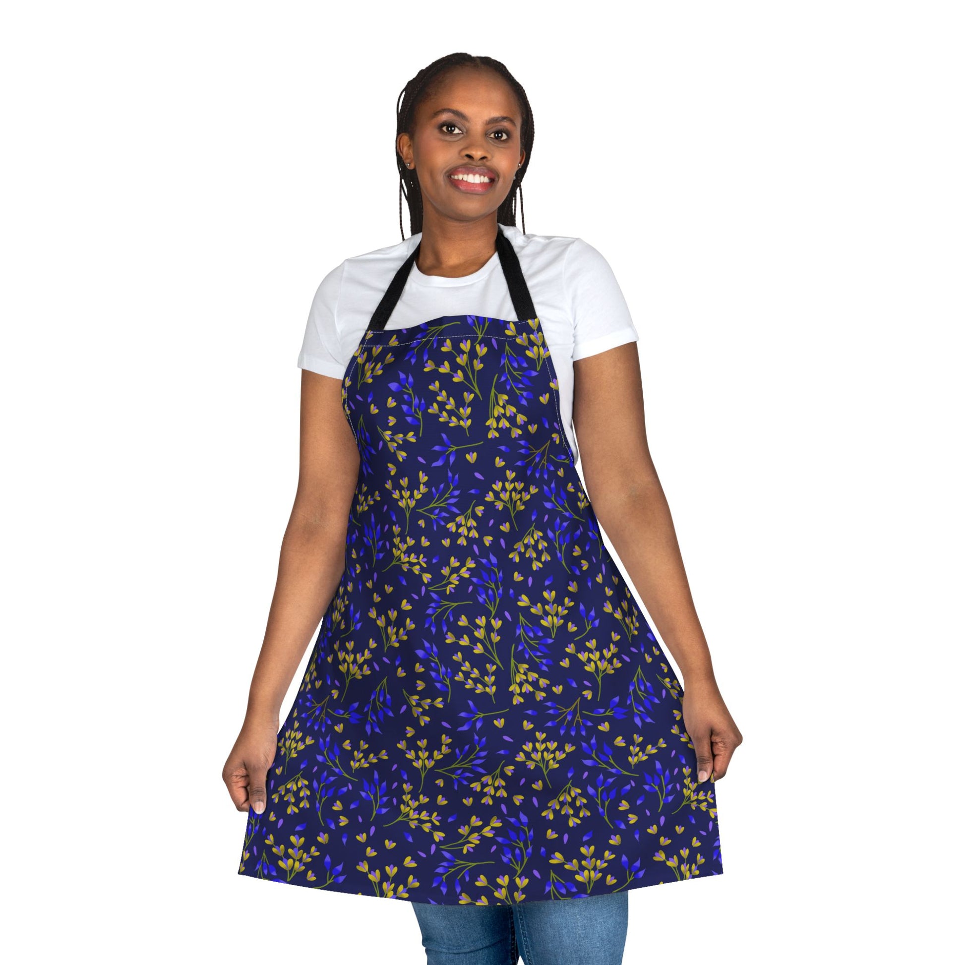 Woman models the Floral Apron from FireBrook Designs, showcasing its vibrant blue botanical pattern. Made of soft, stain-free polyester canvas, it's perfect for cooking or crafting while keeping clothes clean.