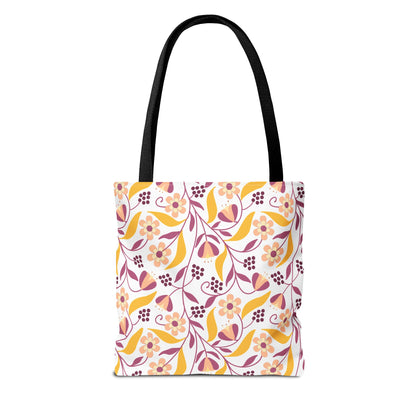 Golden Paisley Floral Tote Bag featuring a vibrant floral-vine pattern in pink, burgundy, and golden yellow on white canvas, with long black handles, ideal for joyful summer outings.