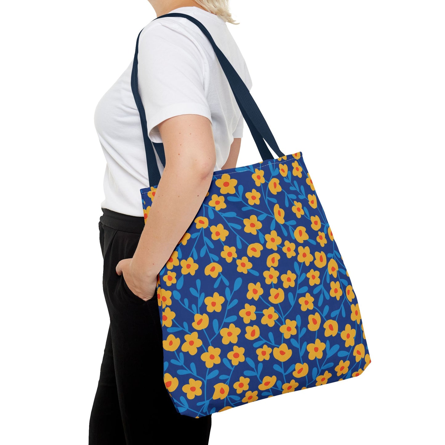 Floral Tote Bag with stylized yellow flowers and blue leaf motifs carried over the shoulder, showcasing FireBrook Designs' uplifting style, perfect for joyful summer outings.
