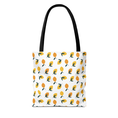 Lemon Drop Toss Tote Bag features a vibrant lemon motif with alternating yellow hues and green leaves, complemented by black straps. Ideal for summer outings, it embodies FireBrook Essentials' joyful, stylish design ethos.