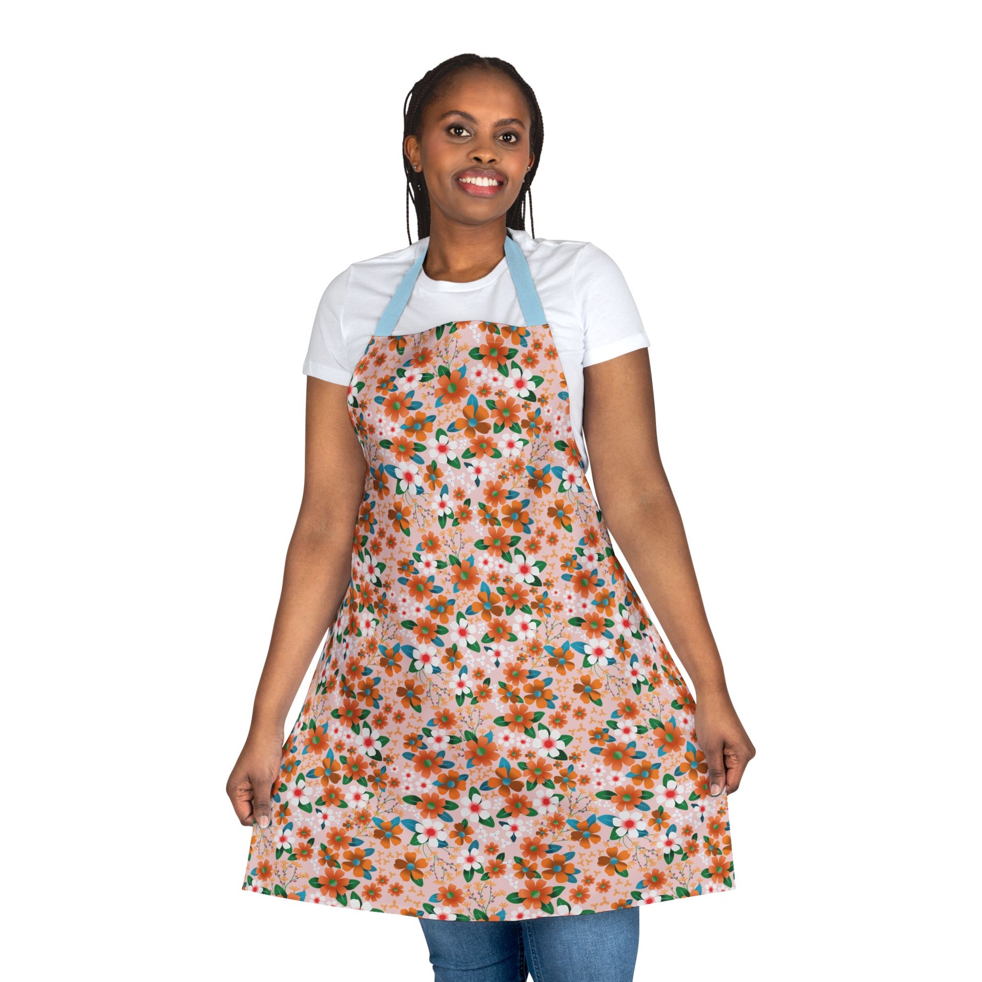 Smiling woman models the Floral Apron from FireBrook Designs, showcasing its vibrant flower pattern and comfortable fit. The apron is perfect for various activities, offering style and stain-free protection.