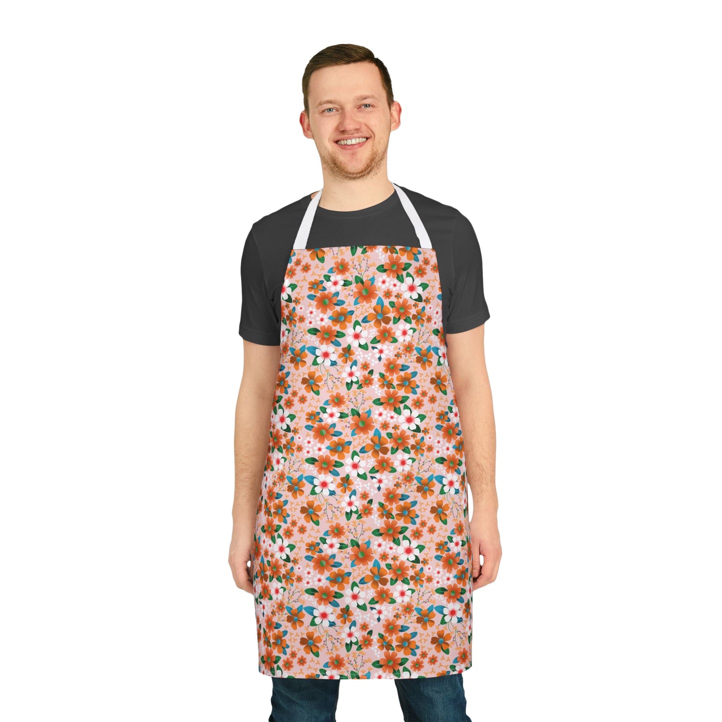 Floral Apron modeled by a man in a dark t-shirt and jeans, featuring vibrant orange and white floral patterns on a light pink background, emphasizing comfort and style from FireBrook Designs.