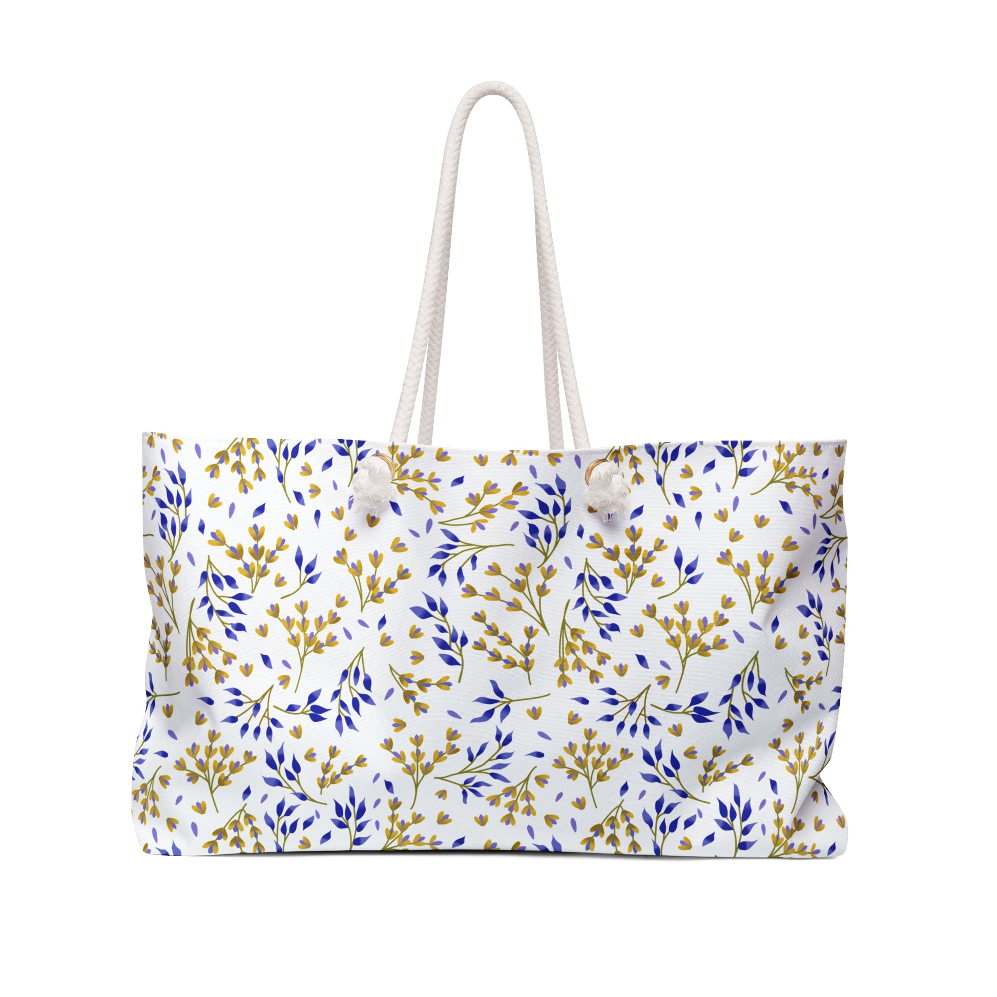 Weekender Bag made from white canvas-like material, featuring knotted rope handles and a botanical pattern of blue and mustard-yellow sprigs, perfectly embodies FireBrook Essentials' stylish, travel-ready design ethos.