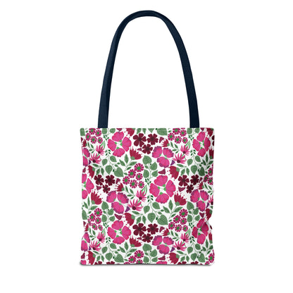 The Pink Lady Tote Bag features vibrant pink and burgundy flowers on a white canvas, paired with navy straps. Ideal for adding a cheerful touch to errands or beach outings.