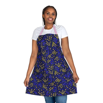 Smiling woman in jeans and T-shirt models FireBrook Essentials' Floral Apron, featuring navy blue with yellow flowers and pink straps, emphasizing comfort for cooking or crafting. Perfect for joyful, mess-free activities.