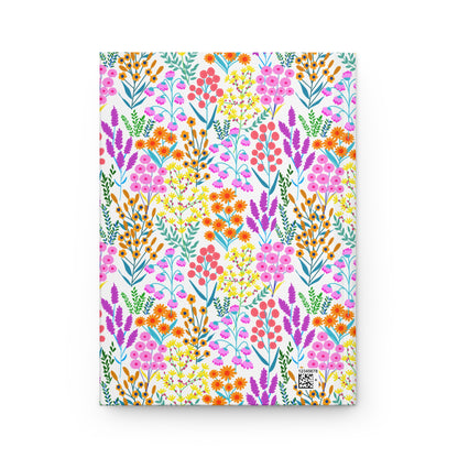 HARDCOVER JOURNAL, MATTE, RULED, 5X7, SEWN BIND, CLEAN-TEAR PAGES - FLORAL MEADOWS: A notebook featuring a vibrant wildflower pattern with pink, orange, and yellow-green foliage, matte finish, and a tiny QR code.