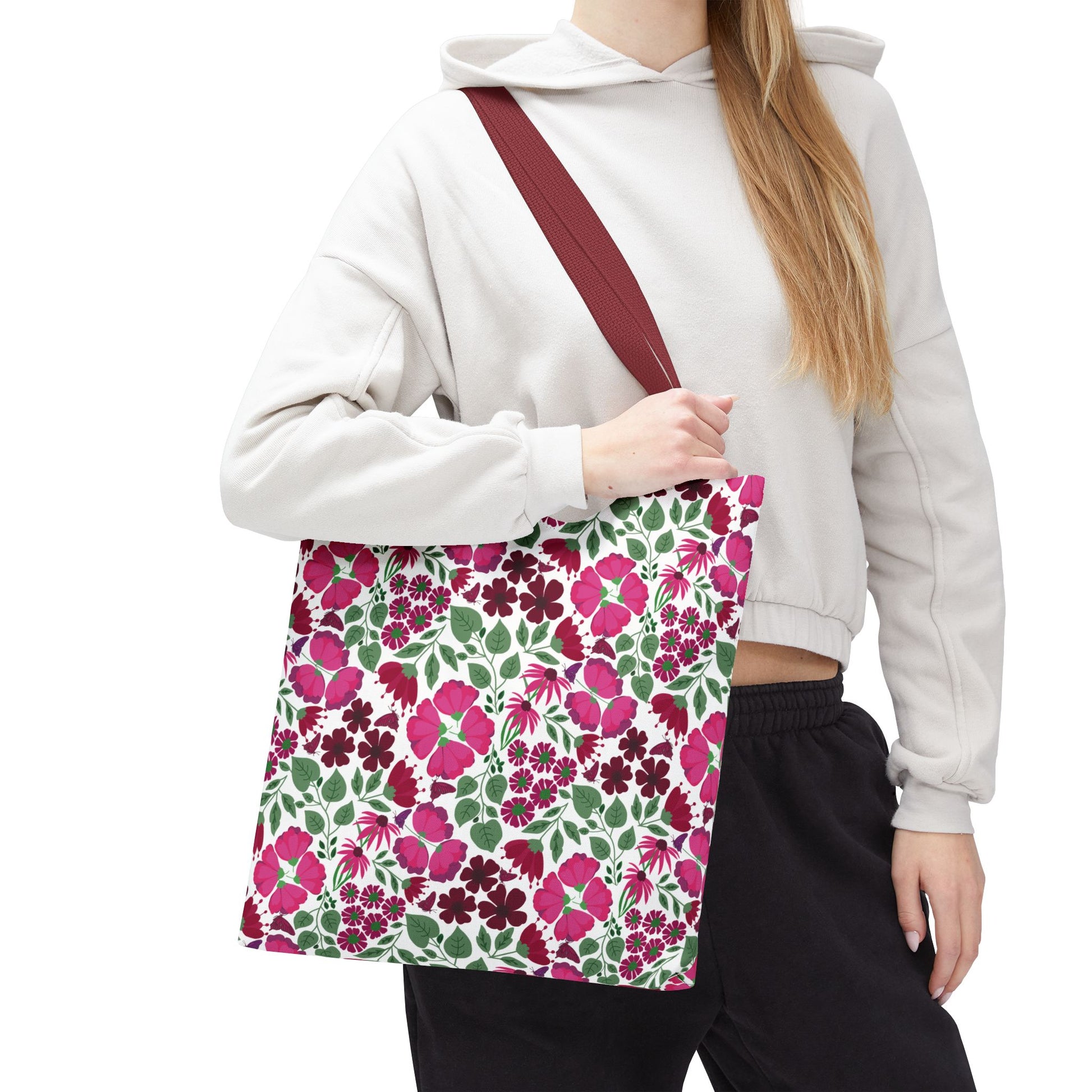 Person holding a Pink Lady Tote Bag featuring vibrant pink and berry floral prints on a white background, embodying FireBrook Designs' uplifting style. Perfect for daily errands or adding color to outfits.