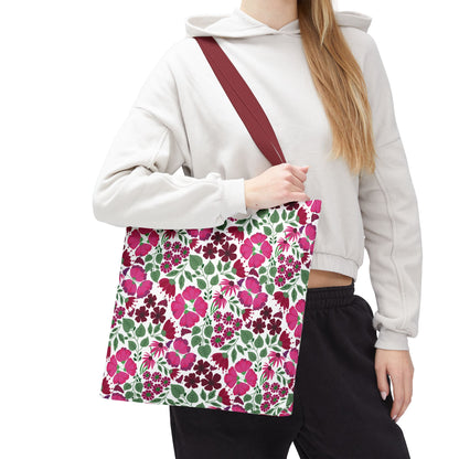 Person holding a Pink Lady Tote Bag featuring vibrant pink and berry floral prints on a white background, embodying FireBrook Designs' uplifting style. Perfect for daily errands or adding color to outfits.