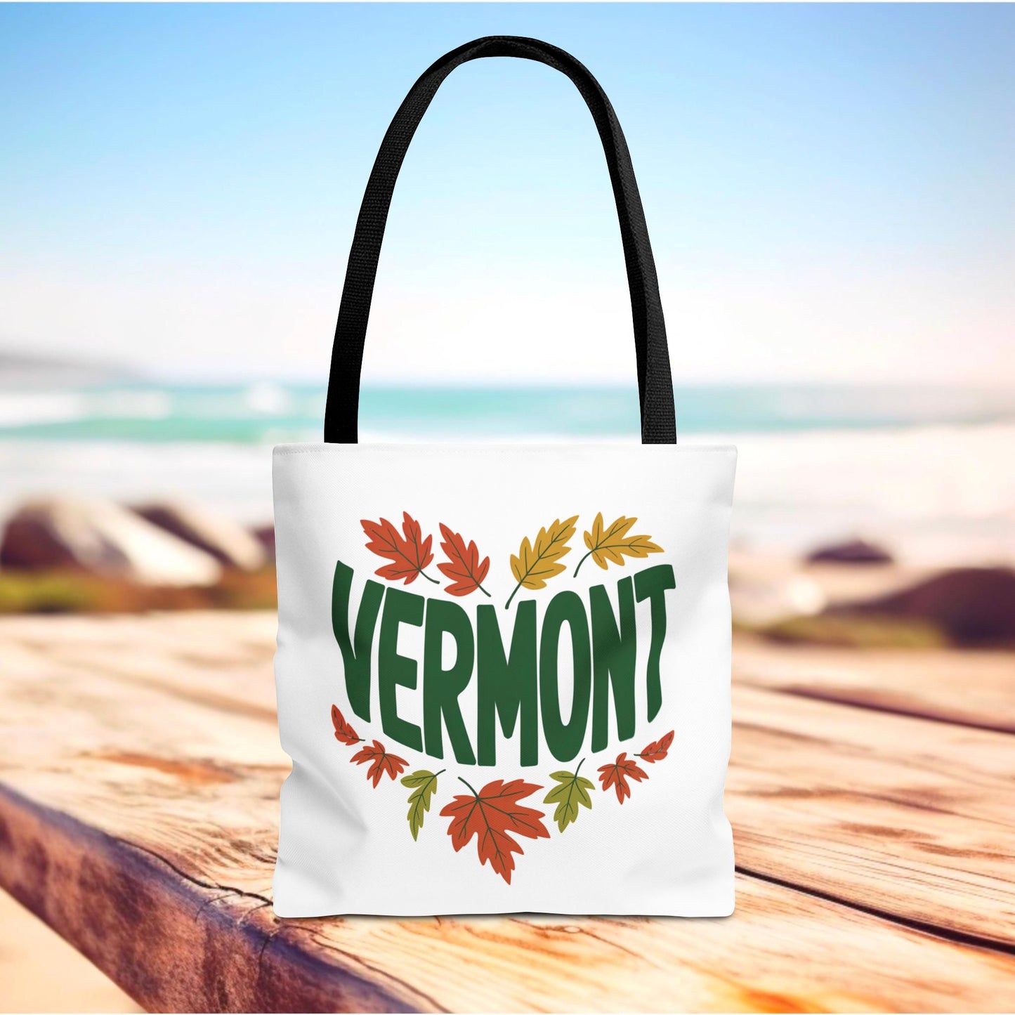 Vermont Tote Bag: A durable, stylish white bag adorned with green and orange leaves. Ideal for daily use, featuring reinforced stitching, boxed corners, and available in multiple sizes from FireBrook Essentials.