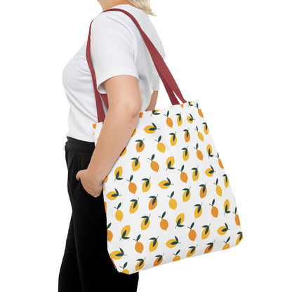 Lemon Tote Bag - Fresh and Fun Citrus Pattern, featuring a vibrant lemon design with green leaves on a white background. Carried over the shoulder, the bag has bold dark-red straps for a stylish summer look.