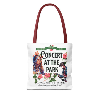 Concert At the Park Tote Bag with a red handle, featuring a lively concert scene with a woman and man playing guitars, ideal for music lovers.