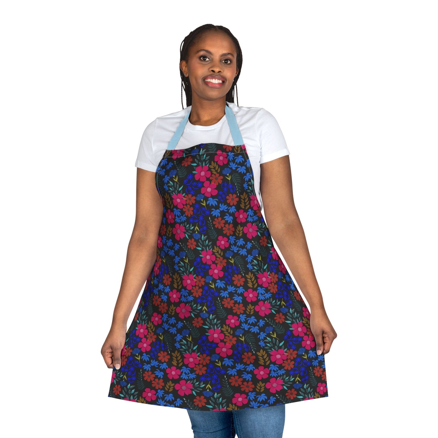 Woman models FireBrook Designs' Apron Floral Design, featuring a colorful floral pattern on a black background, light blue straps, showcasing its stylish, comfortable fit ideal for various activities.