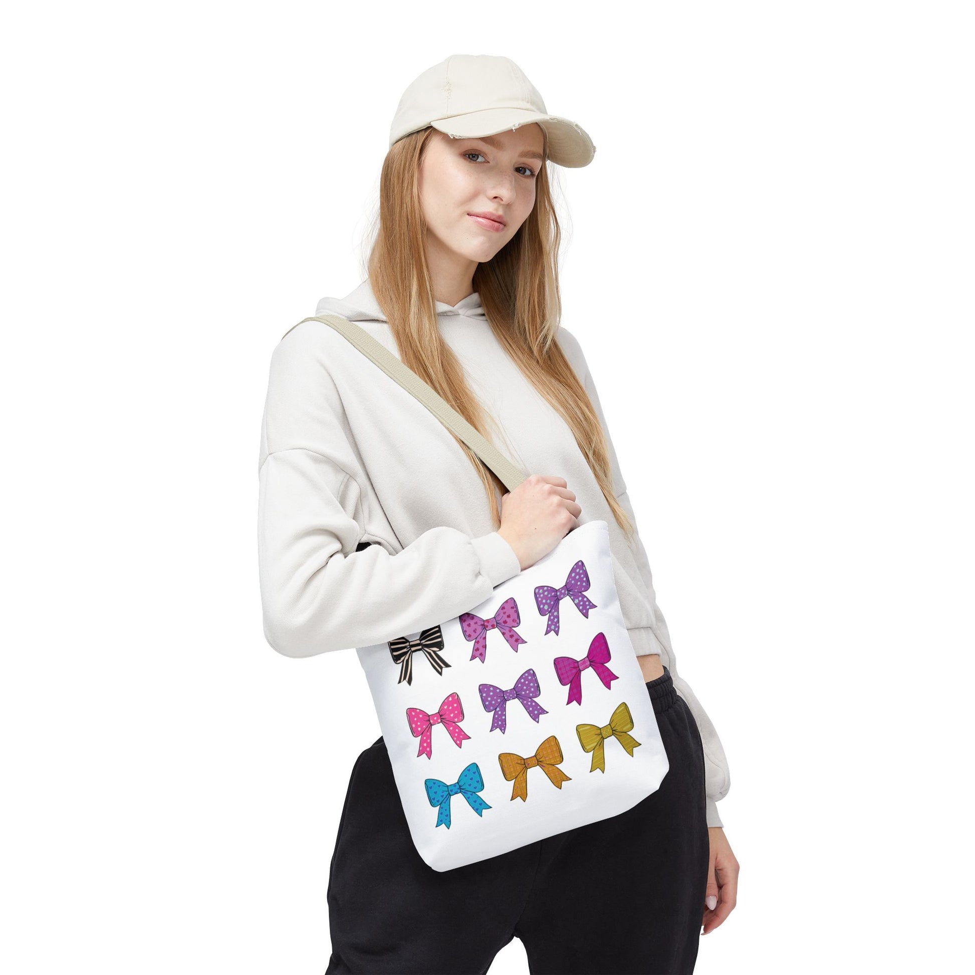 Woman holding a Bows Ribbons Tote Bag with a bow design, showcasing its stylish and practical appeal as part of FireBrook Essentials' uplifting collection.
