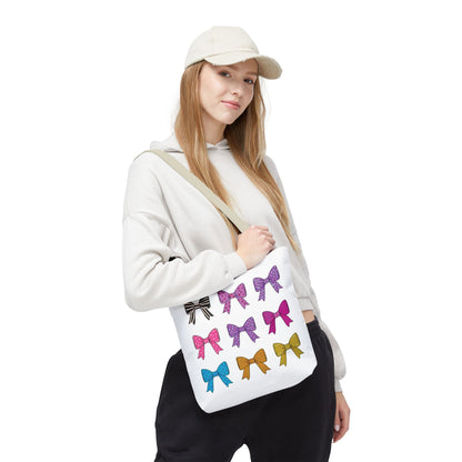 Woman holding a Bows Ribbons Tote Bag with a bow design, showcasing its stylish and practical appeal as part of FireBrook Essentials' uplifting collection.