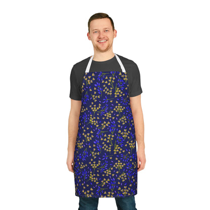 Smiling man wearing a Floral Apron with a navy botanical pattern, featuring white straps. Made from soft, stain-free polyester, ideal for cooking or crafting, epitomizing FireBrook Essentials' stylish, joyful design ethos.