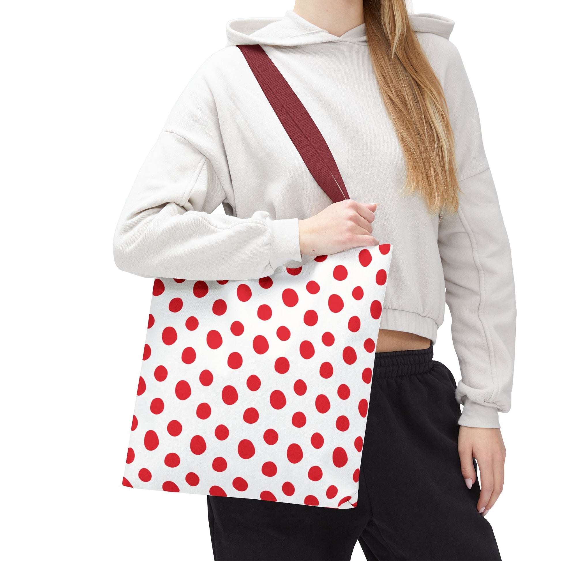 Red Polka Dots Tote Bag held by a woman, showcasing its playful design and durable polyester body. Ideal for everyday use, its vibrant pattern fits perfectly with joyful occasions.