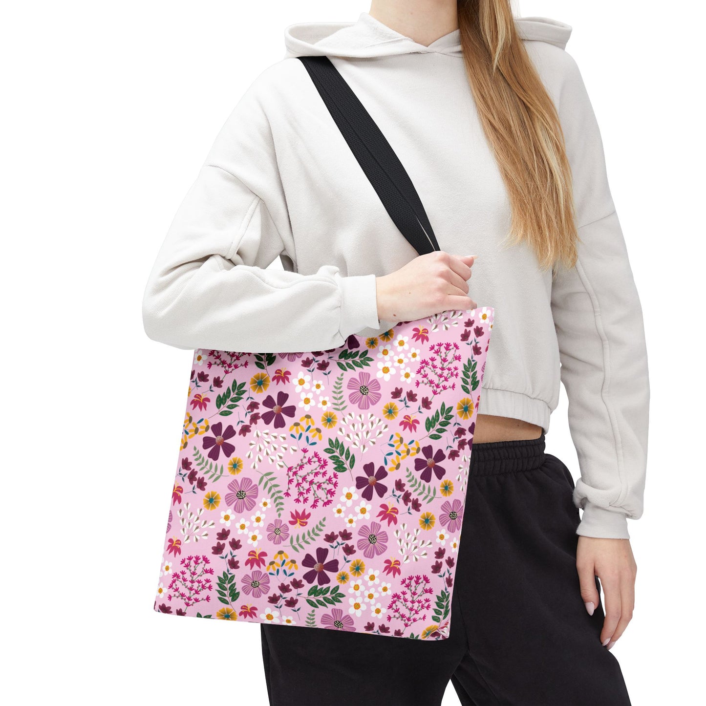 Rose Garden Blush Tote Bag, featuring a pale pink floral pattern with reinforced stitching and black shoulder strap, carried by a person in a light hoodie and dark joggers, embodying FireBrook's stylish durability.