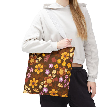 Floral Tote Bag with a retro-style print of orange, yellow, pink, and purple flowers, held by a casually dressed person. Ideal for summer outings, reflecting FireBrook Designs' joyful and uplifting style.