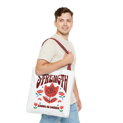 Man holding the Strength Knows No Bounds Tote Bag, featuring a red flower and motivational quote. Designed for strength and style, ideal for everyday use.