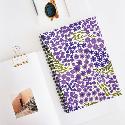 Floral Spiral Notebook with purple flowers and olive leaves on the cover, displayed with sunglasses and an open sketchbook on a white surface, embodying FireBrook Essentials' uplifting and joyful design ethos.