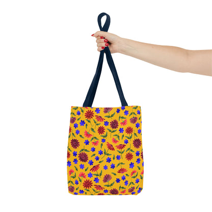 Golden Wildflower Tote Bag with vibrant red and burgundy flowers, small blue blooms, and green leaves on a yellow background, held by black straps, embodying FireBrook Designs' joyful, practical style.