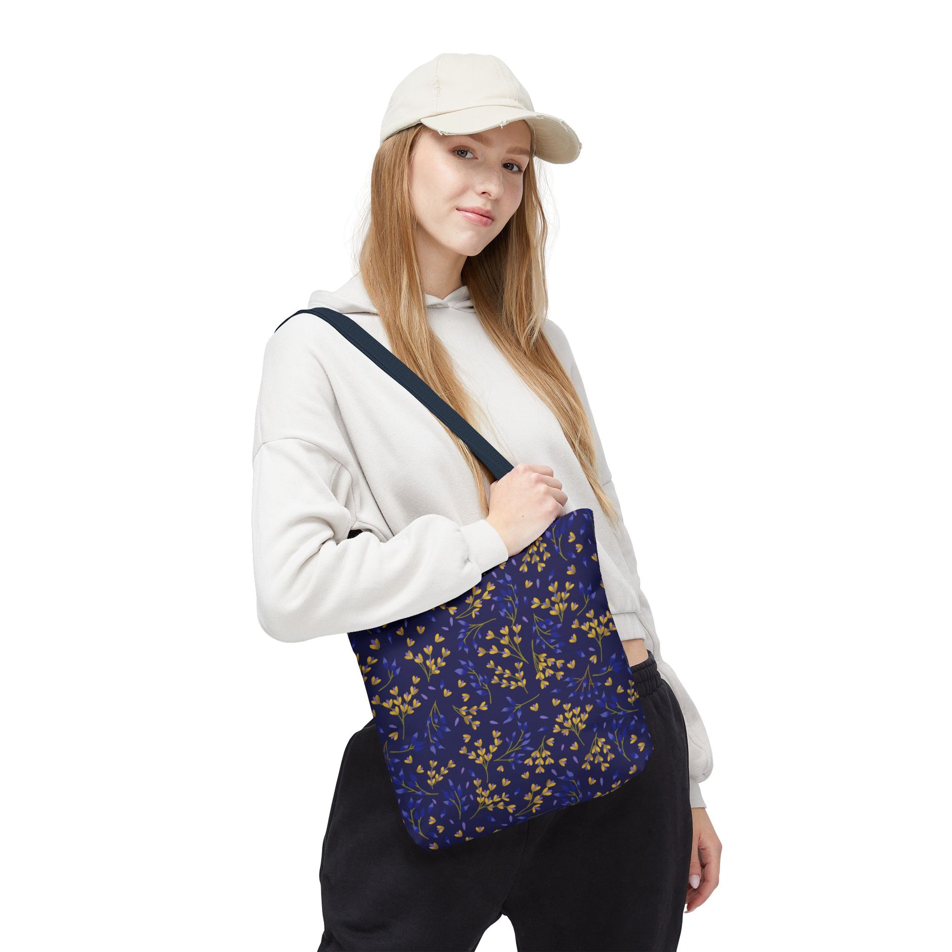 Floral Tote Bag modeled by a young woman, showcasing its deep navy design with vibrant botanical patterns. Ideal for summer, the bag offers style and durability, embodying FireBrook Designs' joyful, uplifting ethos.