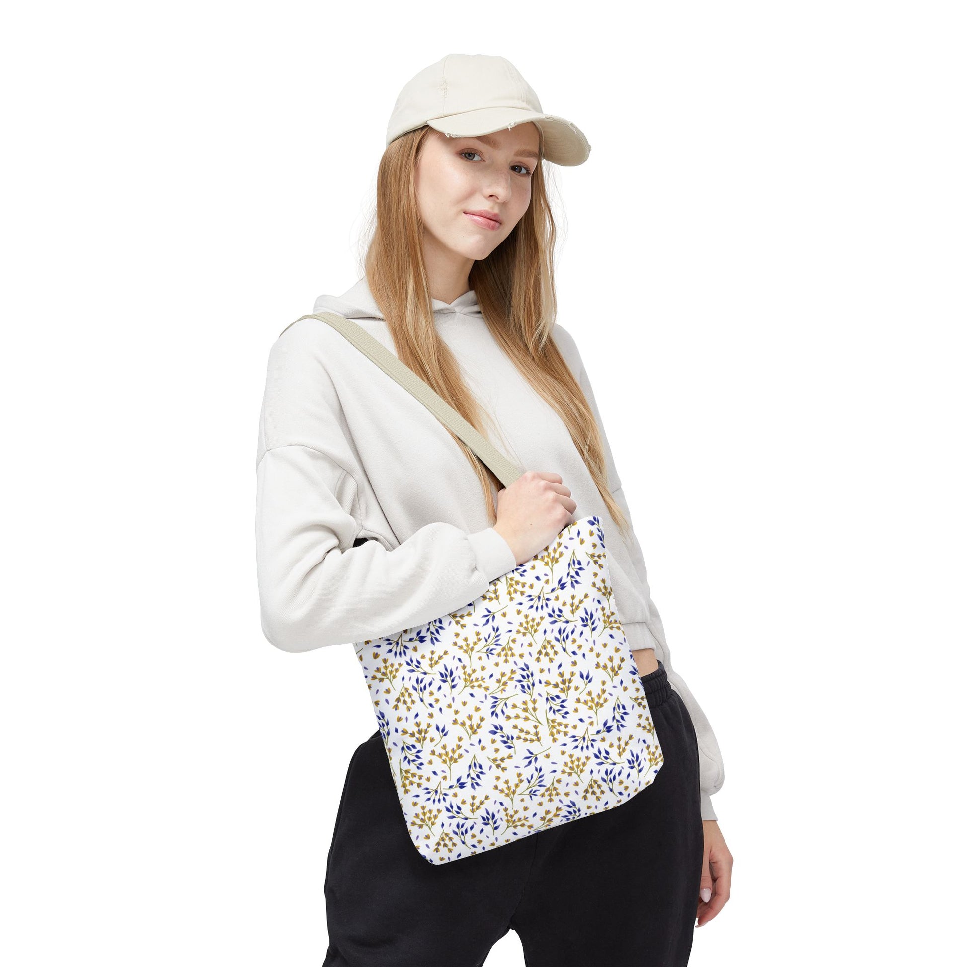 Young woman wearing casual attire carries the Wild Herb Garden Tote Bag, featuring a blue and mustard-yellow floral print, perfect for summer outings. This stylish bag complements FireBrook Designs' uplifting and joyful ethos.