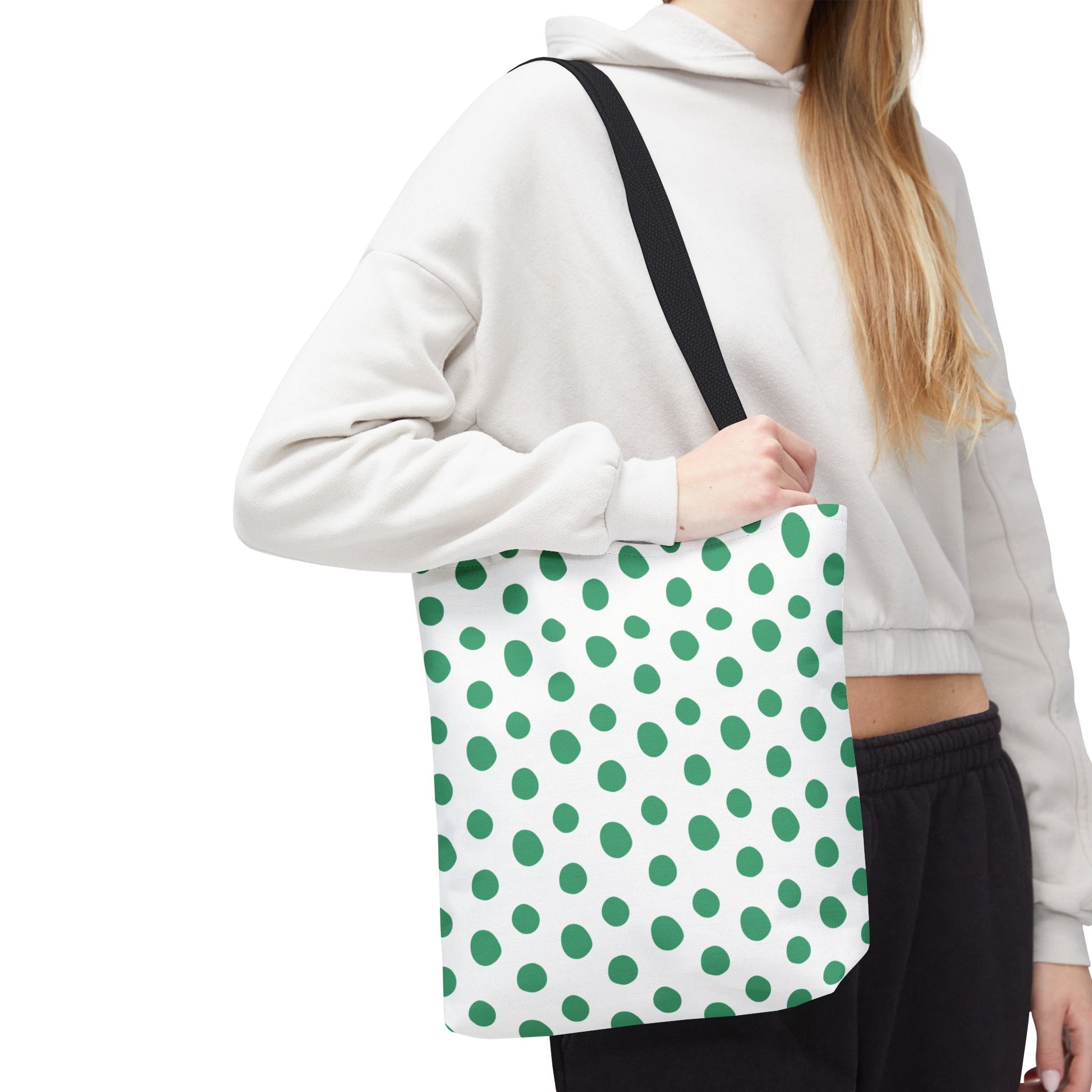A woman holds the Green Polka Dots Tote Bag, showcasing its vibrant, playful design and sturdy build, perfect for adding a cheerful touch to everyday outings.