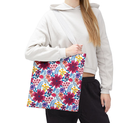 Floral Tote Bag with bright, multicolored blooms and blue foliage against white, worn by a person. Ideal for summer outings, reflecting FireBrook Designs' joyful and uplifting essence.