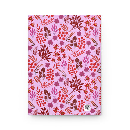 HARDCOVER JOURNAL, MATTE, RULED, 5X7, SEWN BIND, CLEAN-TEAR PAGES – AUTUMN HARVEST displays a vibrant floral pattern with red blossoms and fern-like fronds on a pale pink background, featuring a small inventory code.