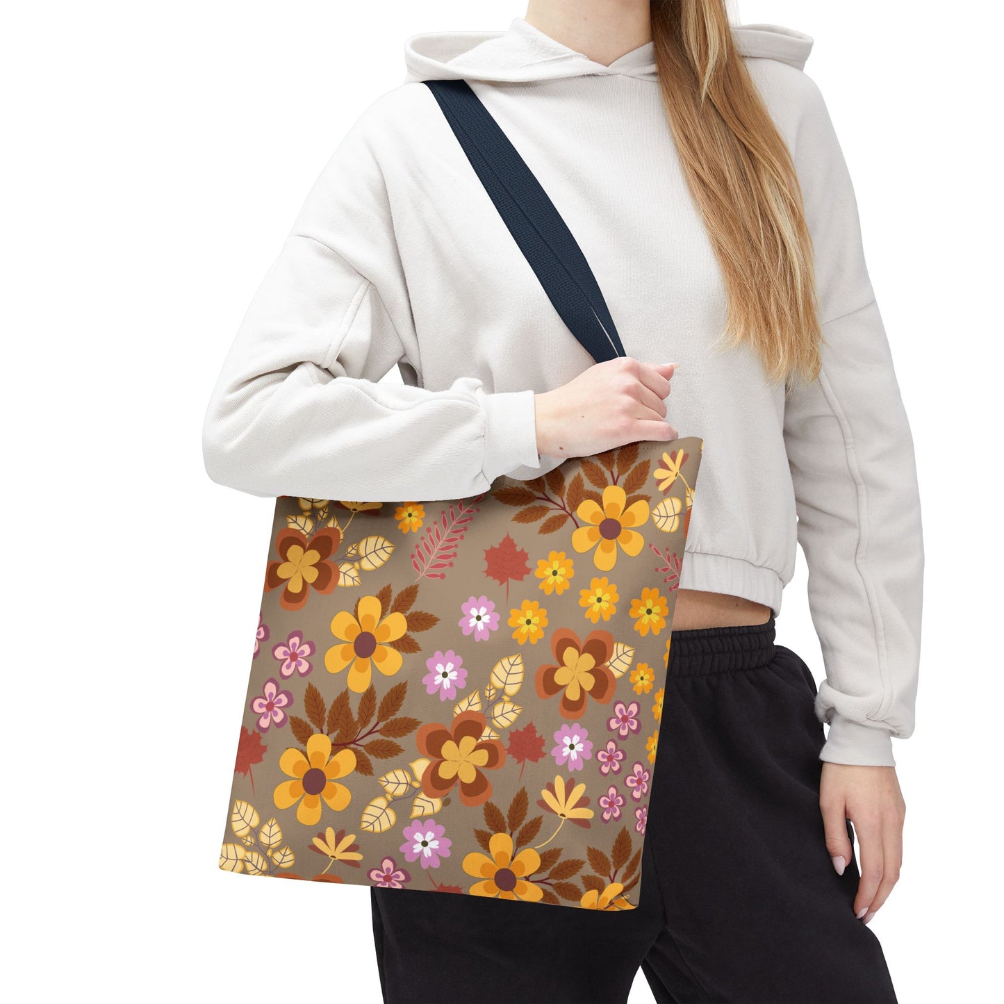 The Harvest Brown Bloom Tote Bag features a retro floral print in warm shades, perfect for summer outings. Its durable polyester body and reinforced handles make it stylish and functional.
