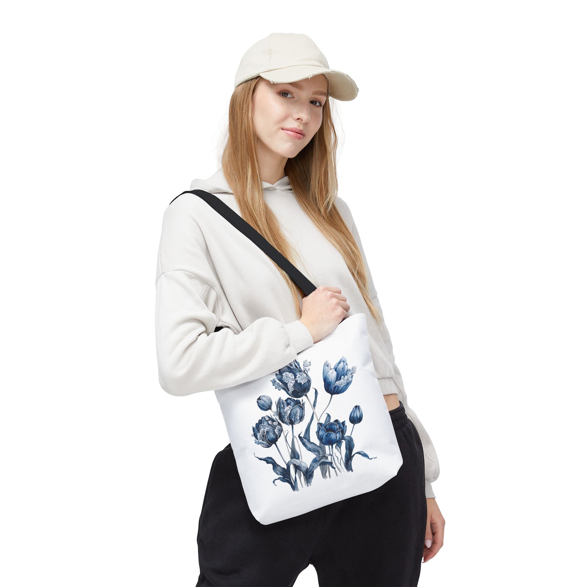 Woman in a hat holding the Flowers in Blue Hue Watercolor Tote Bag, showcasing its floral design, ideal for stylish, practical use.