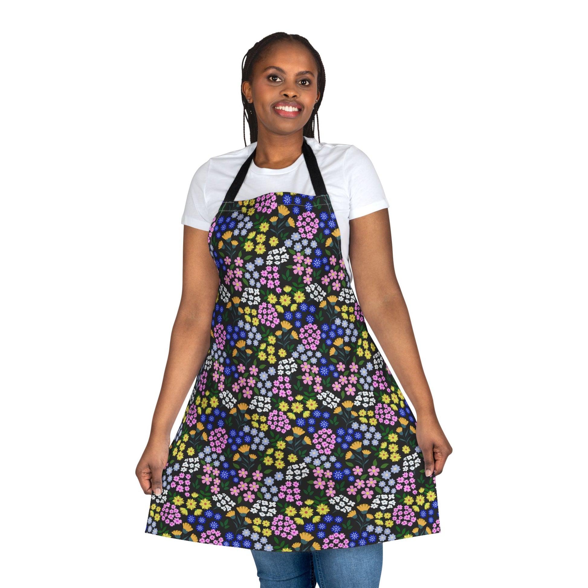 Apron Floral Design: Woman models a vibrant floral apron with a black background. The full-coverage apron, made of soft polyester canvas, showcases a colorful pattern, emphasizing comfort and style.