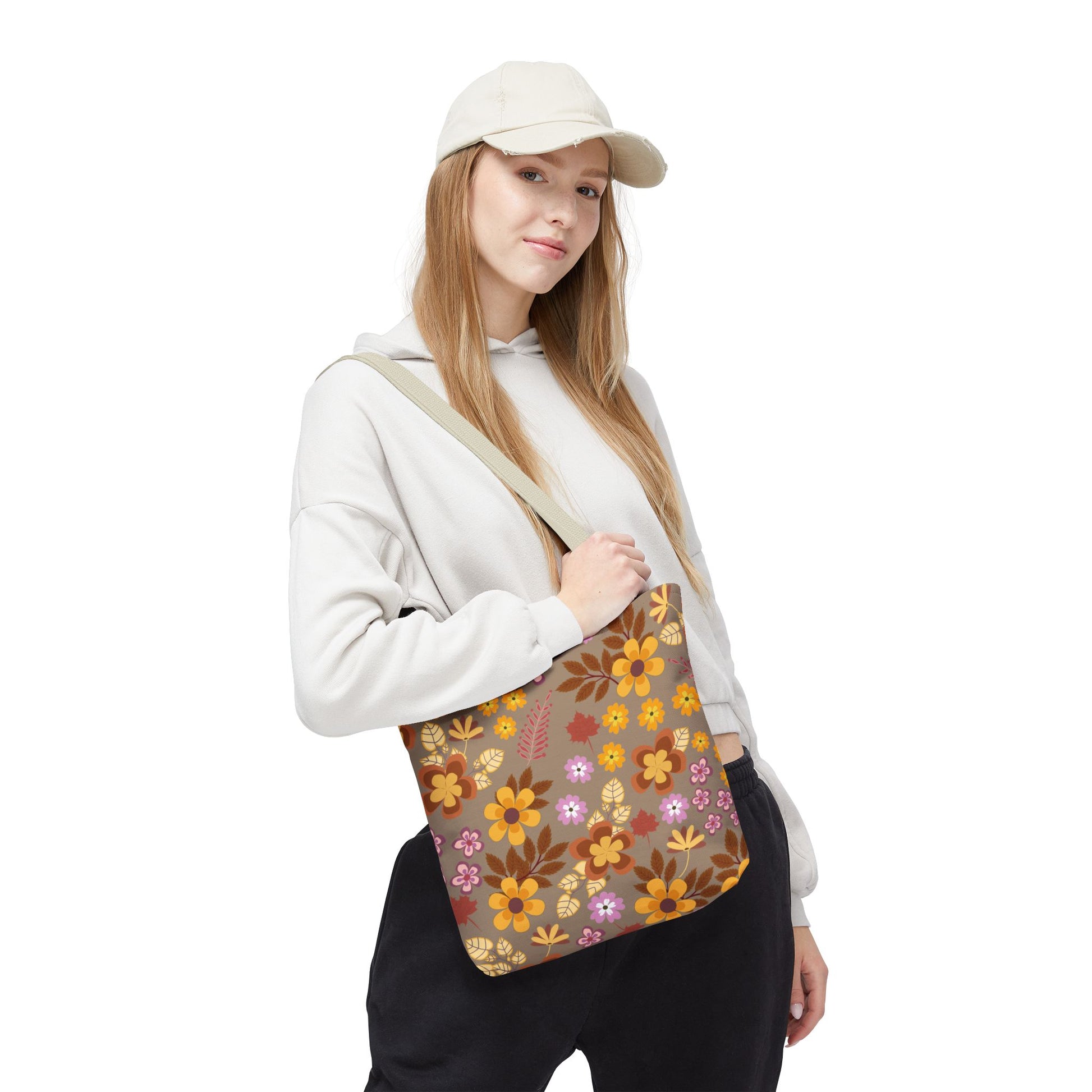 Young woman models the Harvest Brown Bloom Tote Bag, featuring autumnal floral design and a wide strap, perfect for brightening up outings. Ideal for stylishly carrying essentials with joy.