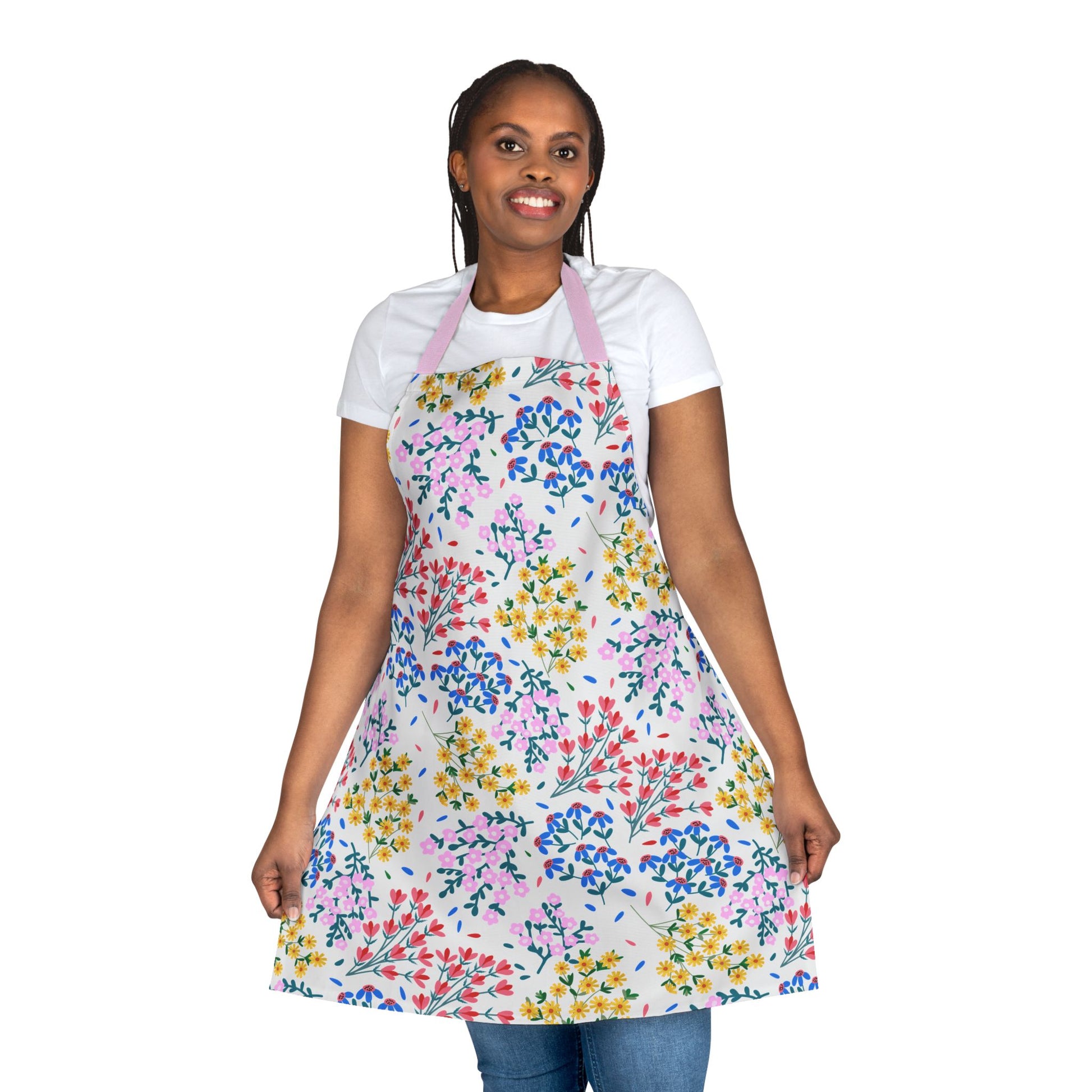 Smiling woman wearing FireBrook Designs' Floral Apron with colorful floral sprigs, featuring a pale pink neck strap. Ideal for baking or crafting, offering comfort and style. Perfect for joyful, everyday use.