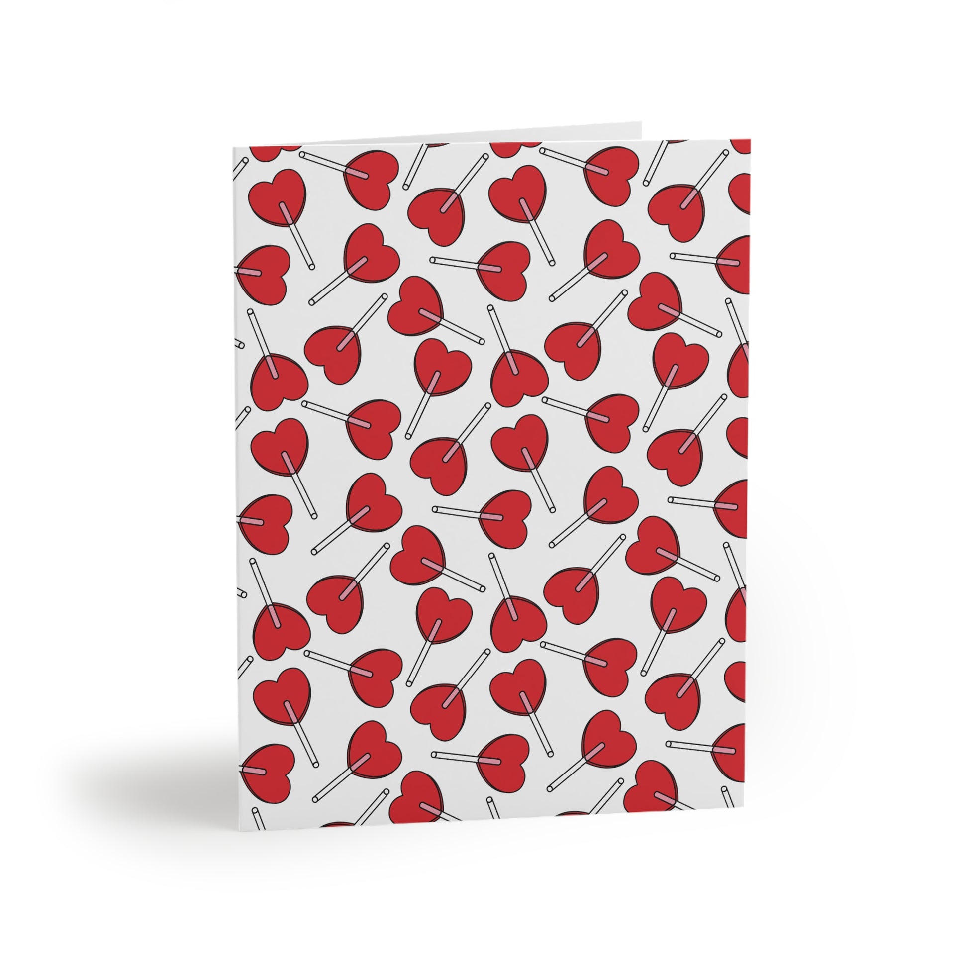 Love Greeting Cards — Pack of 8/16/24 featuring a delightful edge-to-edge pattern of red heart-shaped lollipops on a white background. Matte-finish, folded, with a matching white envelope.