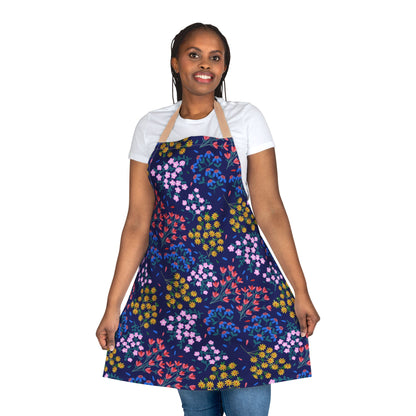 Woman in a white T-shirt models a Floral Apron with a vibrant multicolored pattern, showcasing its shape. The apron is designed for comfort and style, aligning with FireBrook Essentials' joyful, uplifting ethos.