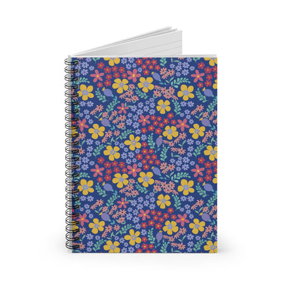 Floral Spiral Notebook with vibrant blooms and foliage on a deep blue cover, upright against a white background, showcasing its sleek metal spiral binding and ruled pages for creative note-taking.