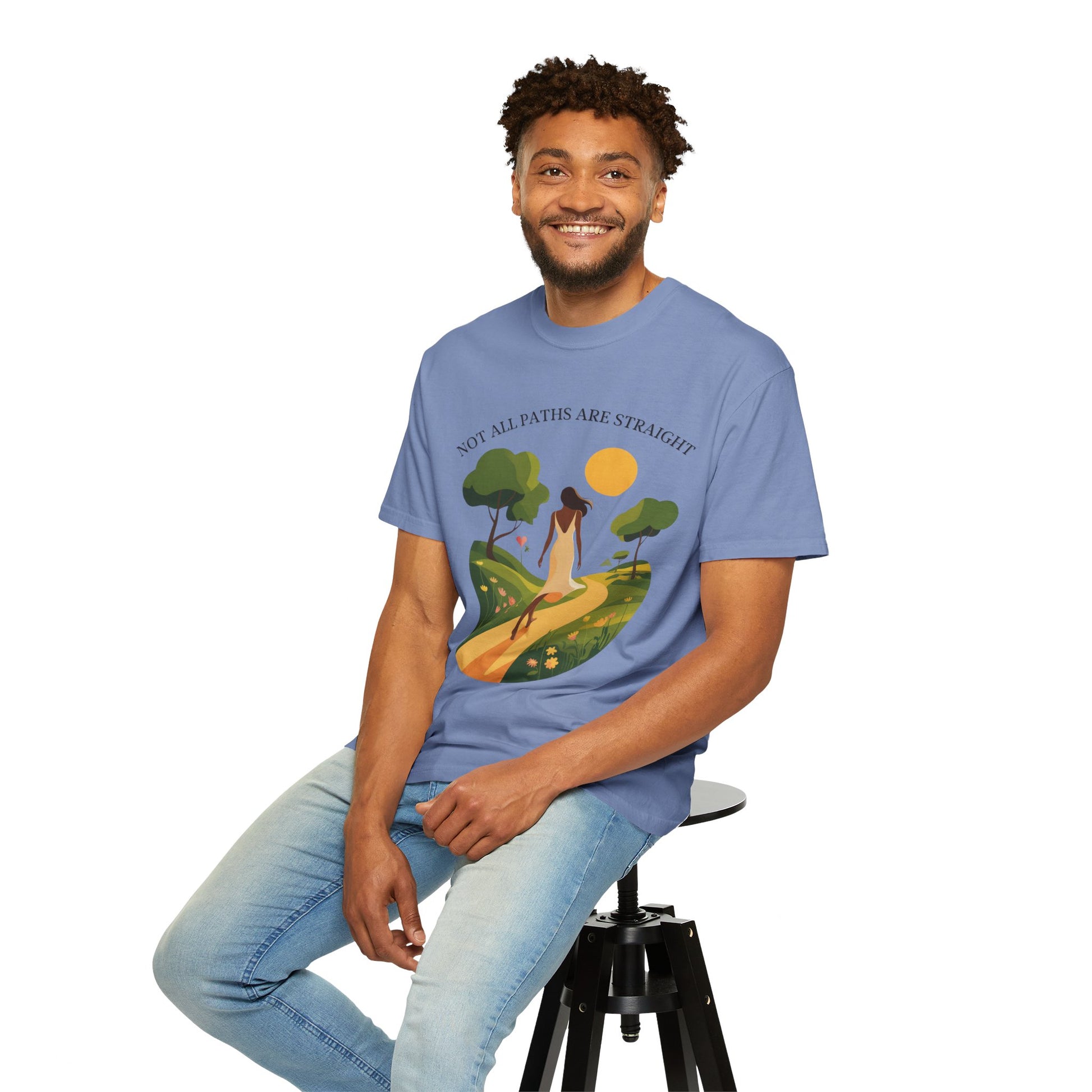 Inspirational Message T-Shirt featuring Not All Paths Are Straight worn by a smiling man sitting on a stool, showcasing the relaxed fit and garment-dyed fabric for casual, motivational wear.